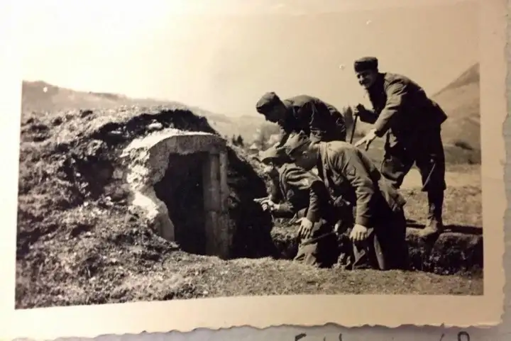 La entrada de un búnker abandonado, tres soldados están claramente posando para la foto